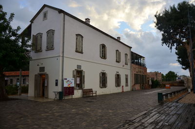 Street by buildings in town against sky