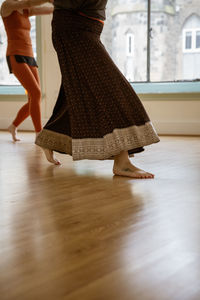 Low section of woman dancing on hardwood floor