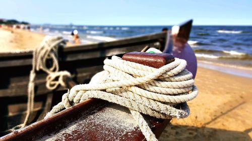 Close-up of rope tied on boat moored at harbor