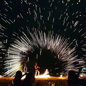 People watching firework display at night