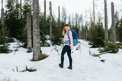 Hiking outdoors. a young woman tourist with a backpack walks through the forest and enjoys nature.