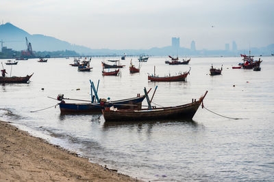 Boats moored in sea against sky