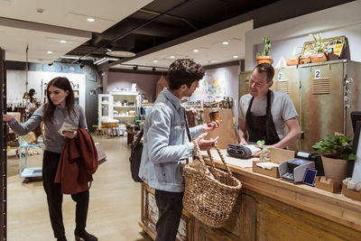 Male customer buying merchandise from salesman at boutique