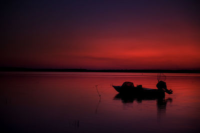 The motorboat was moored to the shore. bright red sunset on the lake. calm and peaceful. 