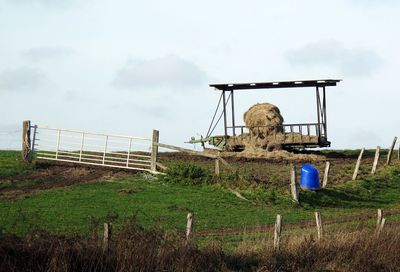 Traditional windmill on field against sky