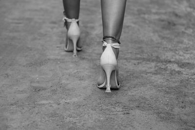 Low section of woman wearing high heels walking outdoors