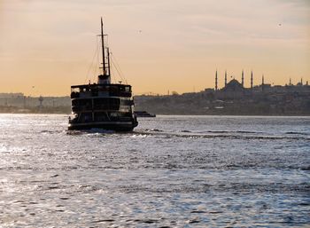 Boats in sea at sunset