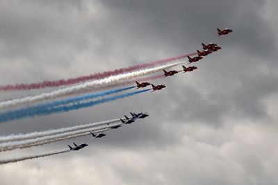 Low angle view of airplane in airshow against sky