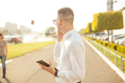 Side view of young man using mobile phone