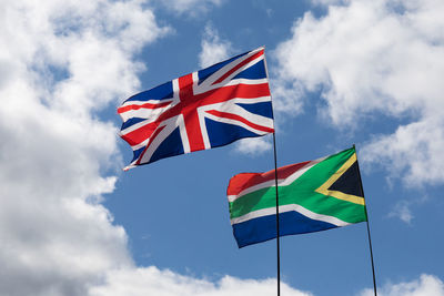 Low angle view of flags waving against sky