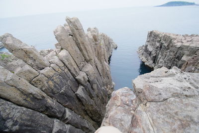 Rock formation on beach against clear sky