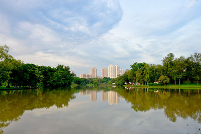 Scenic view of lake by buildings against sky