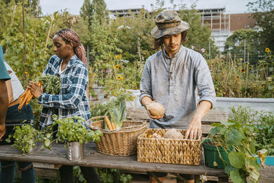 Multiracial male and female farmers selling vegetables in market