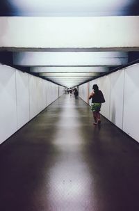 Rear view of woman walking in corridor