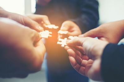 Cropped image of friends playing jigsaw puzzle