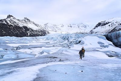 Man with snow on mountain against sky