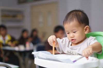 Cute girl writing on paper over table