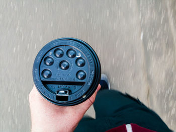 Close-up of hand holding sealed disposable drink container