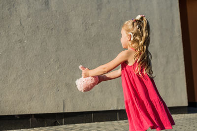 Rear view of woman standing against wall