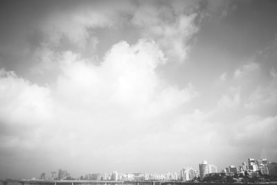 View of cityscape against cloudy sky