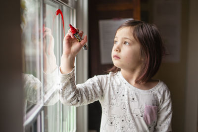 Girl looking away while standing at home