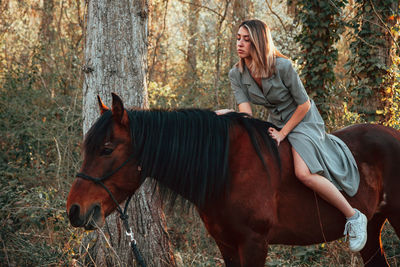 Full length of young woman with horse