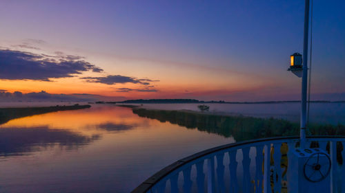 Scenic view of lake against sky at sunset