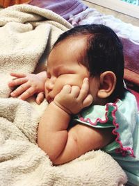 Close-up of baby sleeping in bed