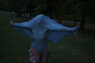 Rear view of woman standing on field