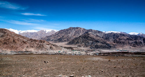 Scenic view of mountains against blue sky