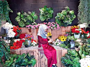 Woman standing by potted plant for sale