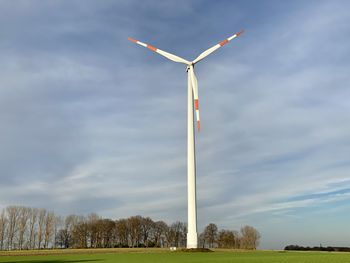 Low angle view of windmill on field against sky