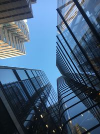 Low angle view of office buildings against blue sky