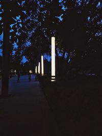 Silhouette people walking on footpath at night