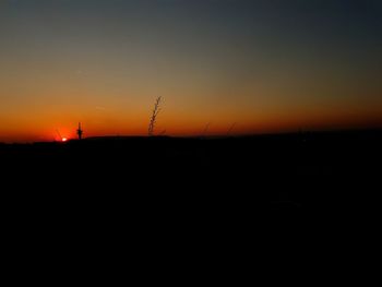 Scenic view of silhouette shore against sky during sunset