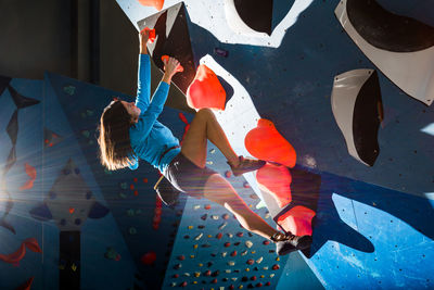 Athletic girl climbing on an indoor climbing wall