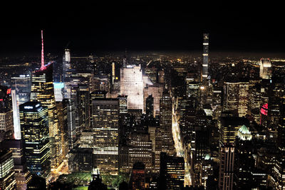 Illuminated cityscape against sky at night