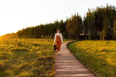 Woman botanist on ecological hiking trail. naturalist exploring wildlife ecotourism walking on path