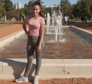 Full length of teenage girl standing in fountain