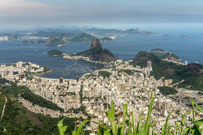 High angle view of city by sea against sky