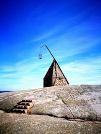 Low angle view of old lighthouse against blue sky