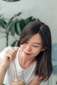 Portrait of a beautiful young woman drinking glass