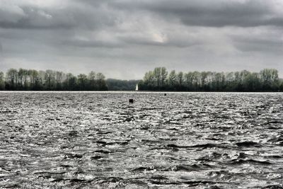 Scenic view of lake against cloudy sky