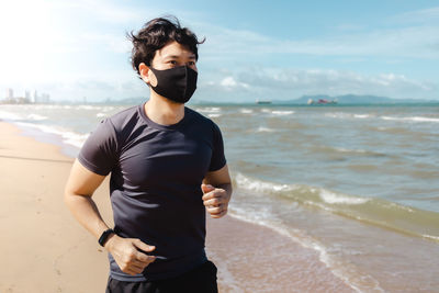 Young man standing on beach