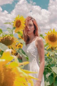 Woman standing by yellow flowering plants