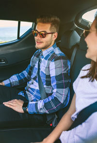 Happy young couple on road trip in car