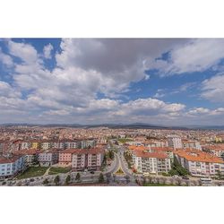 View of cityscape against cloudy sky