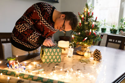 Young man packs christmas presents for friends and family