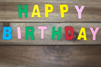 Happy birthday colorful text on wooden table