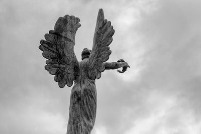 Low angle view of angel statue against sky